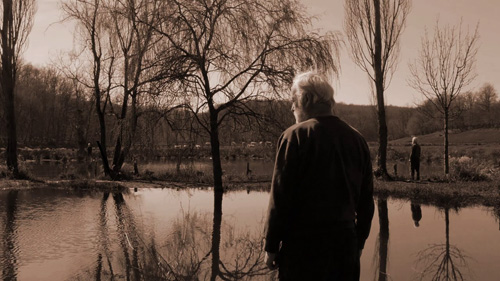 Thumbnail for Exploring Time - showing a figure standing before a reflective stretch of water